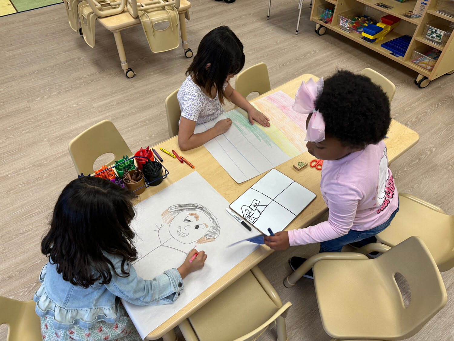CHhildren drawing after school inside one of the classrooms at the Children's Promise Centers child...