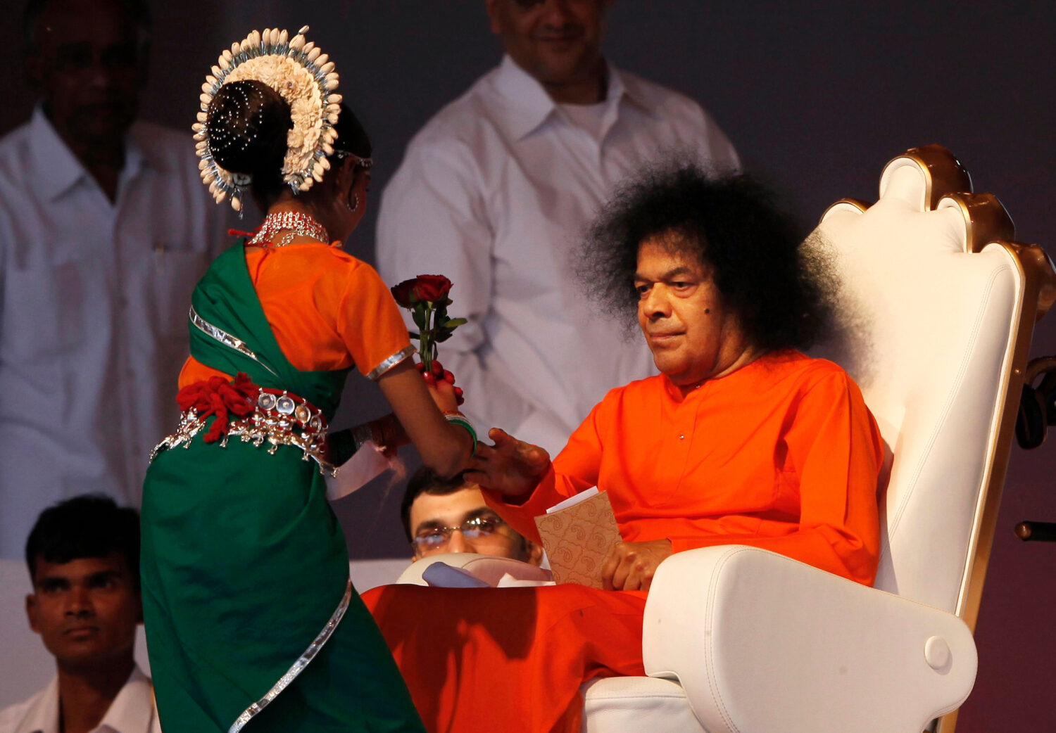 FILE - Indian spiritual leader Sathya Sai Baba, right, receives a flower from a girl at a function ...