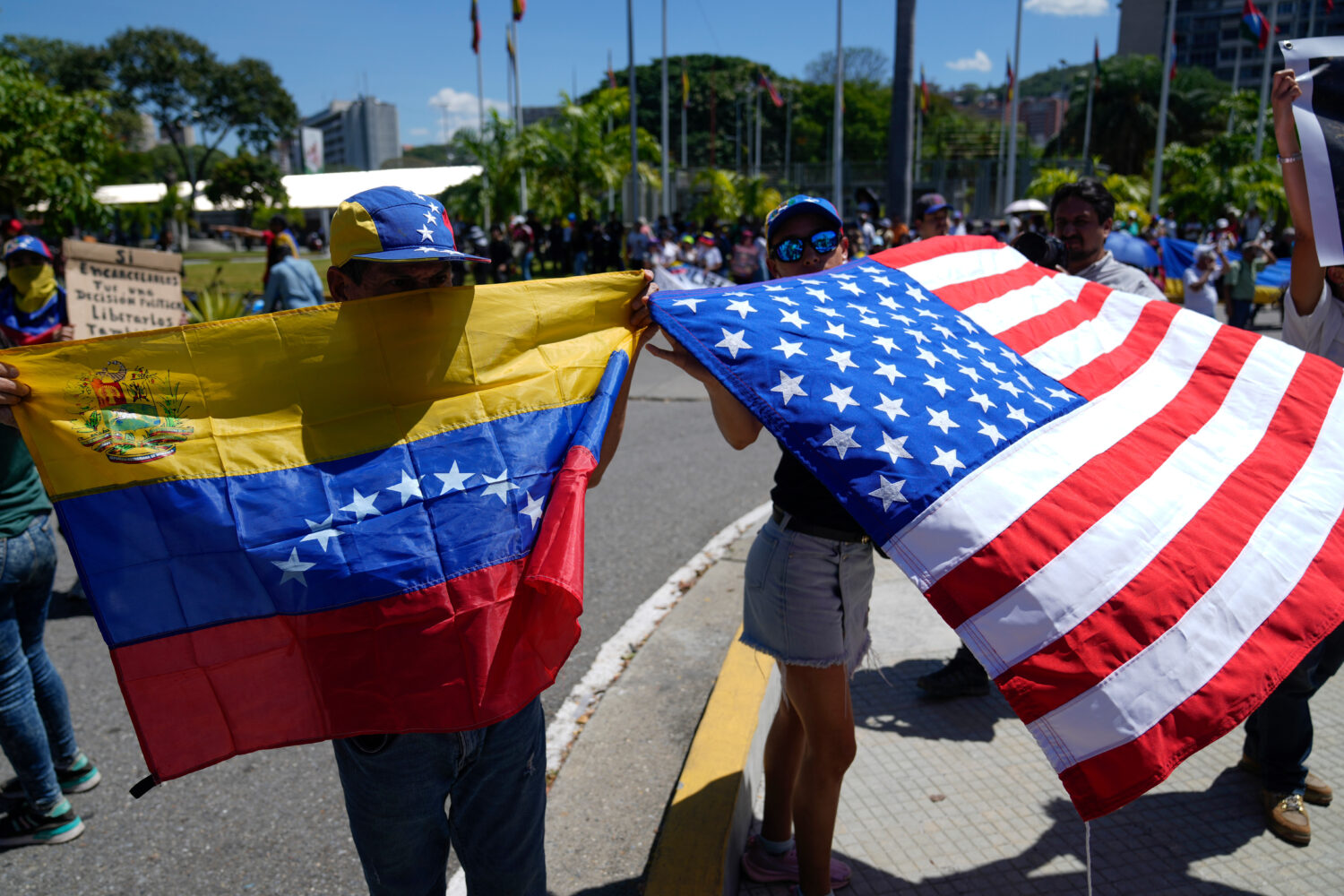 Demonstrators hold a Venezuelan and U.S. national flags during a student-led march calling for the ...