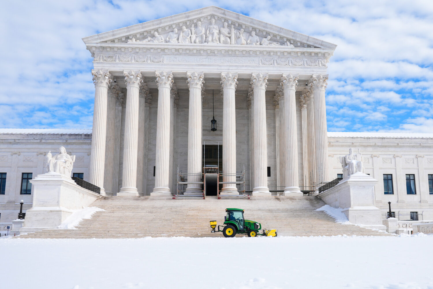 A worker clears snow at the U.S. Supreme Court after a snowstorm Monday, Jan. 26, 2026, in Washingt...