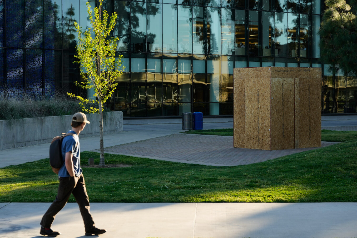A student looks toward a plywood box covering a statue of César Chavez at California State Univers...