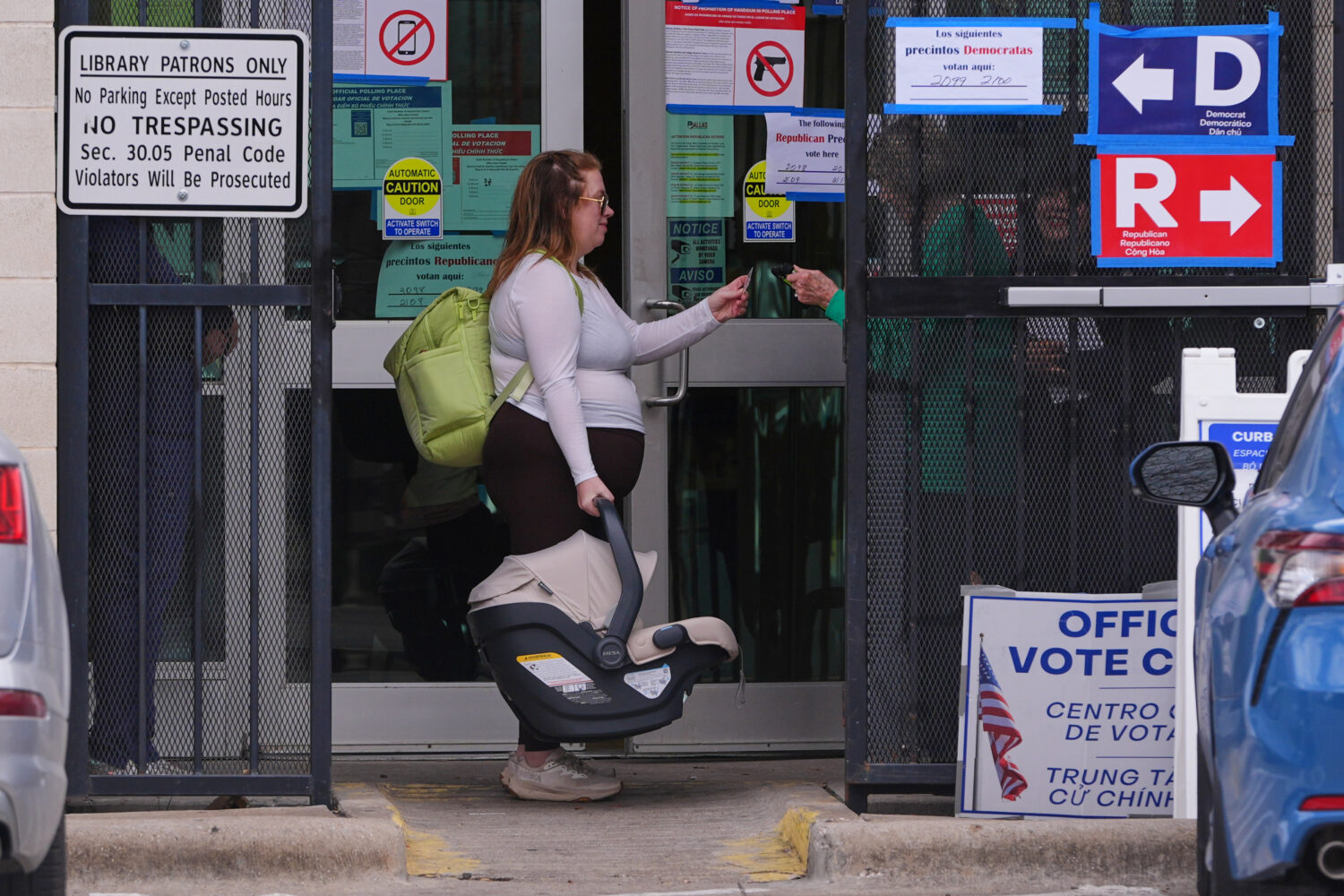 Primary voter Allie Davis carries her seven-week-old son Declan as a Dallas County Election Navigat...