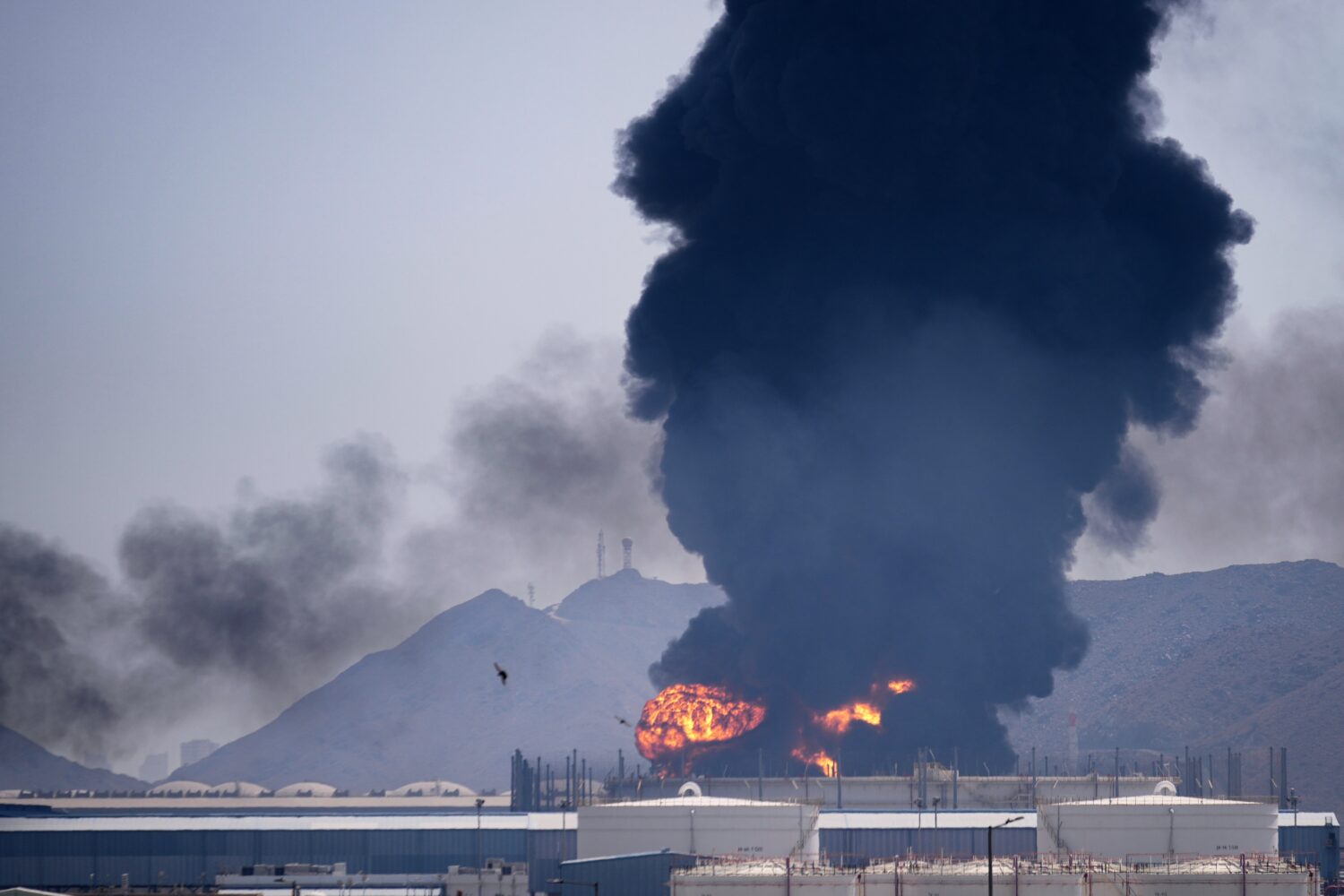 A fire and plume of smoke rise after, according to authorities. debris from an intercepted Iranian ...