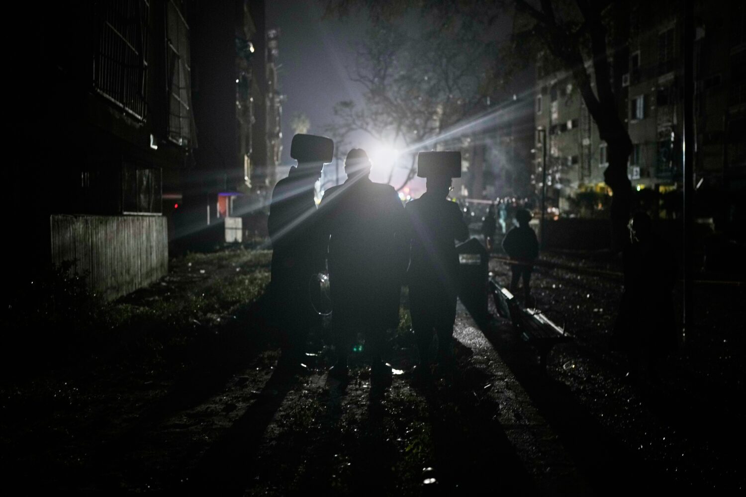 Ultra-Orthodox Jewish men watch as Israeli security forces and rescue teams operate at the site hit...