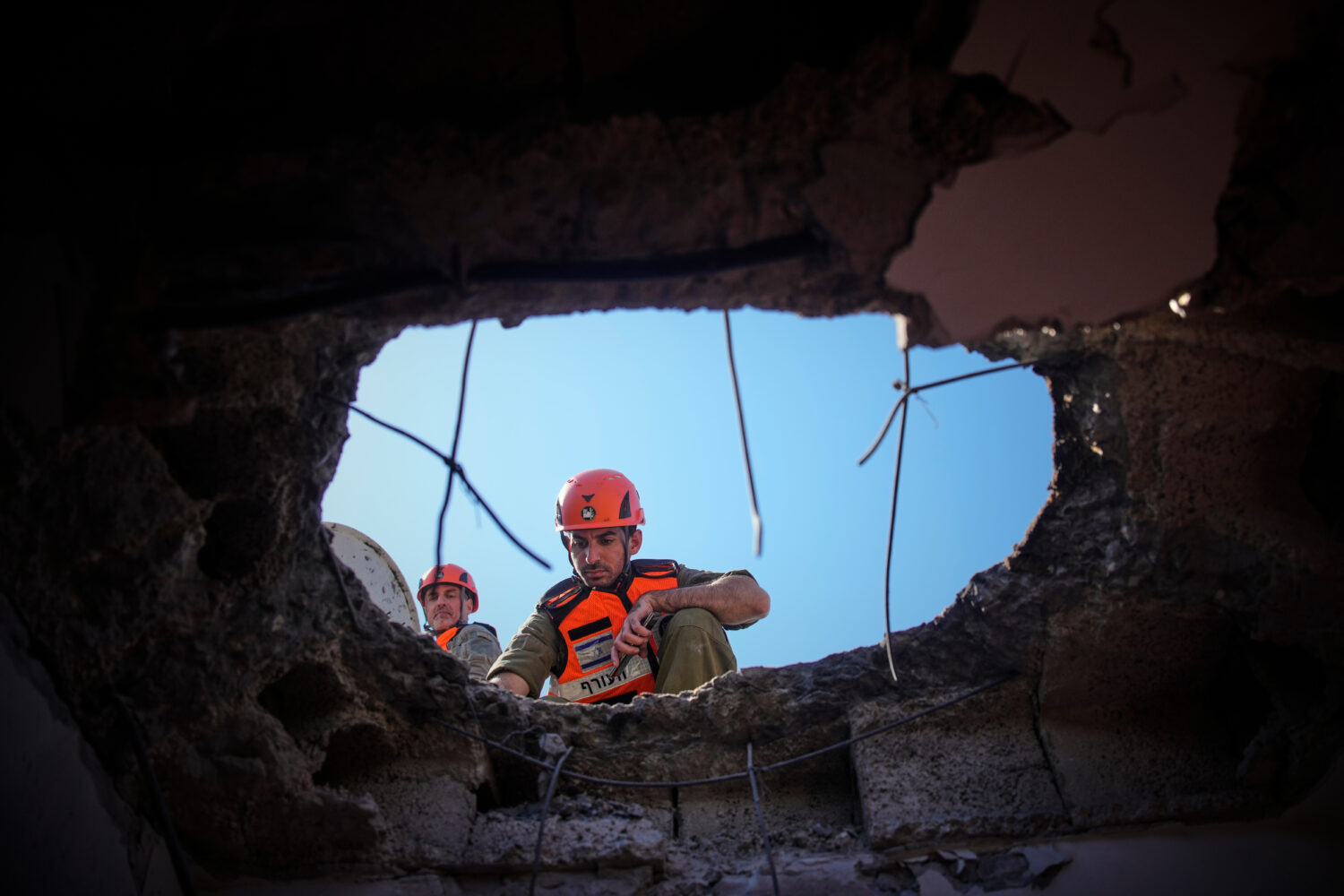 Officers from Israel's Home Front Command inspect a damaged apartment building after an Iranian mis...