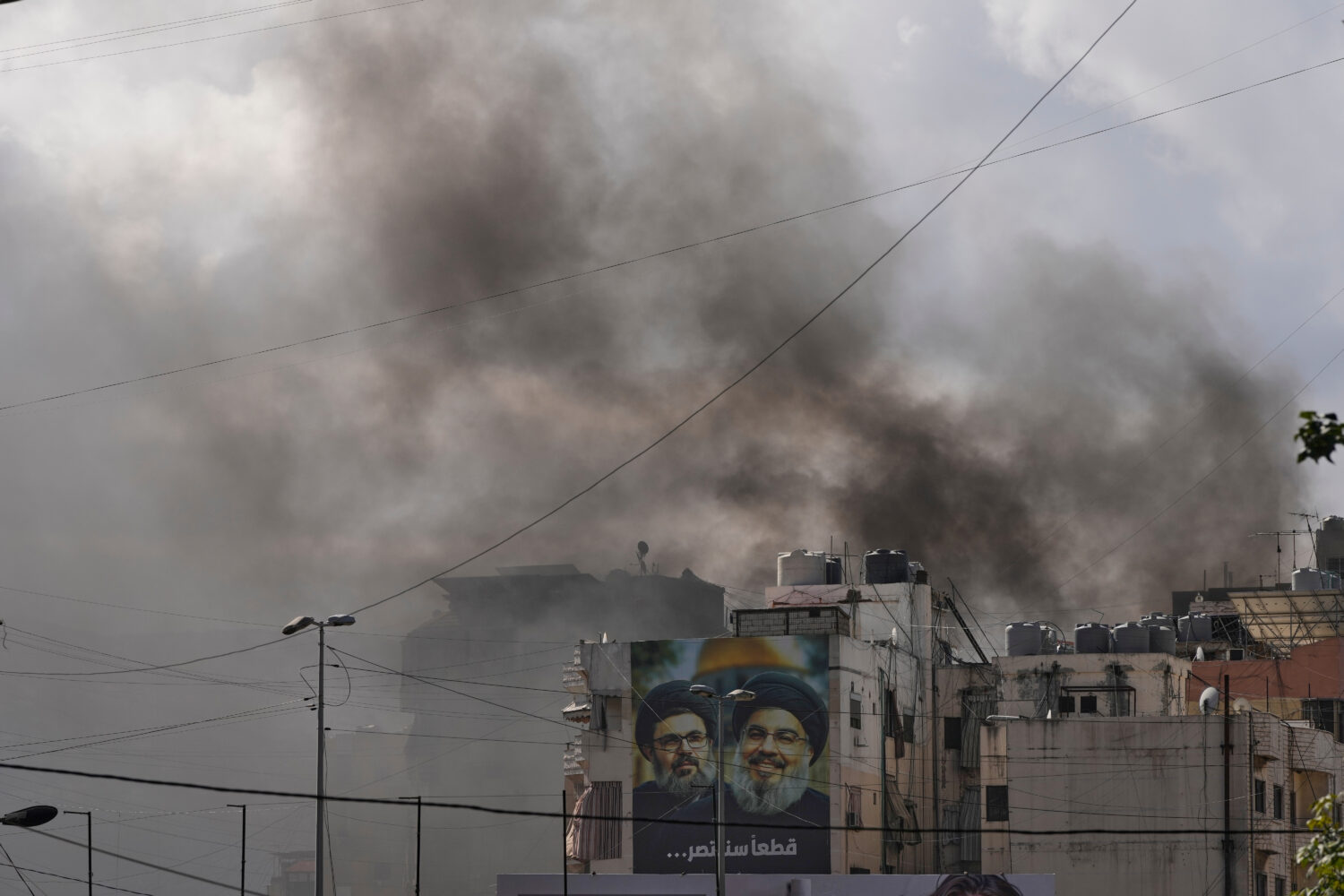 Portraits of Hezbollah's late leaders Hassan Nasrallah, right, and his cousin, Hashem Safieddine, a...