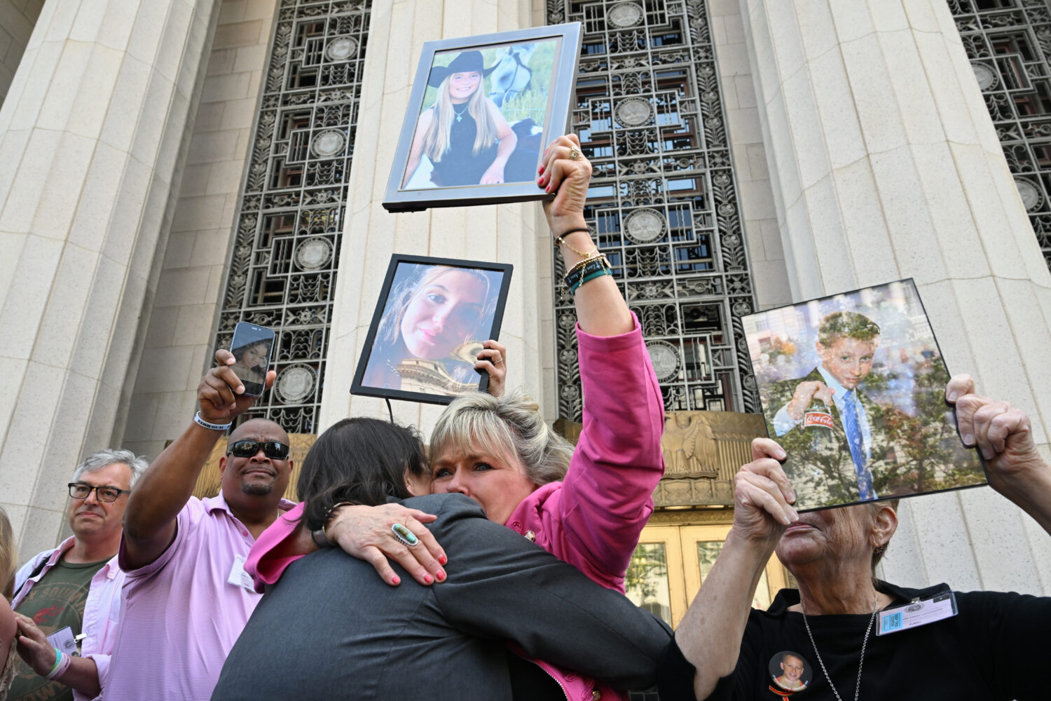Lori Schott, center, is embraced as she holds up a photo of her daughter Annalee Schott, after the ...