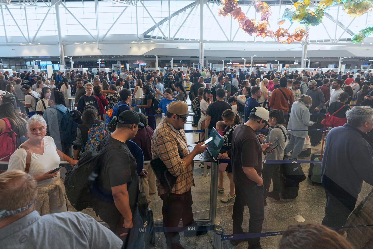 Passengers wait in a security checkpoint line at George Bush Intercontinental Airport Wednesday, Ma...