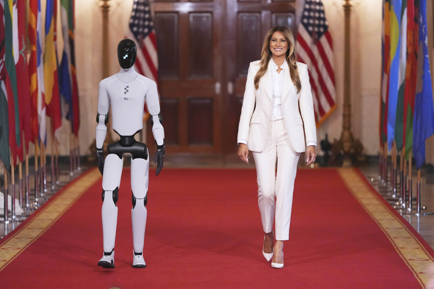 First lady Melania Trump arrives, accompanied by a robot, to attend the "Fostering the Future Toget...
