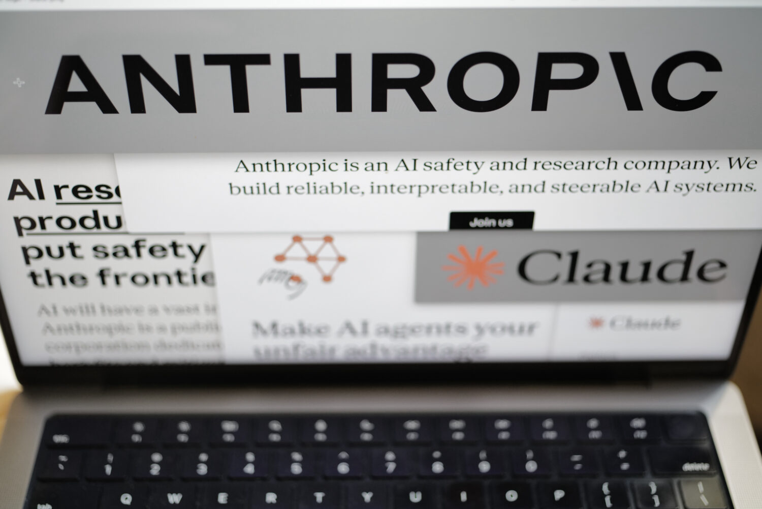 Pages from the Anthropic website and the company's logos are displayed on a computer screen in New ...