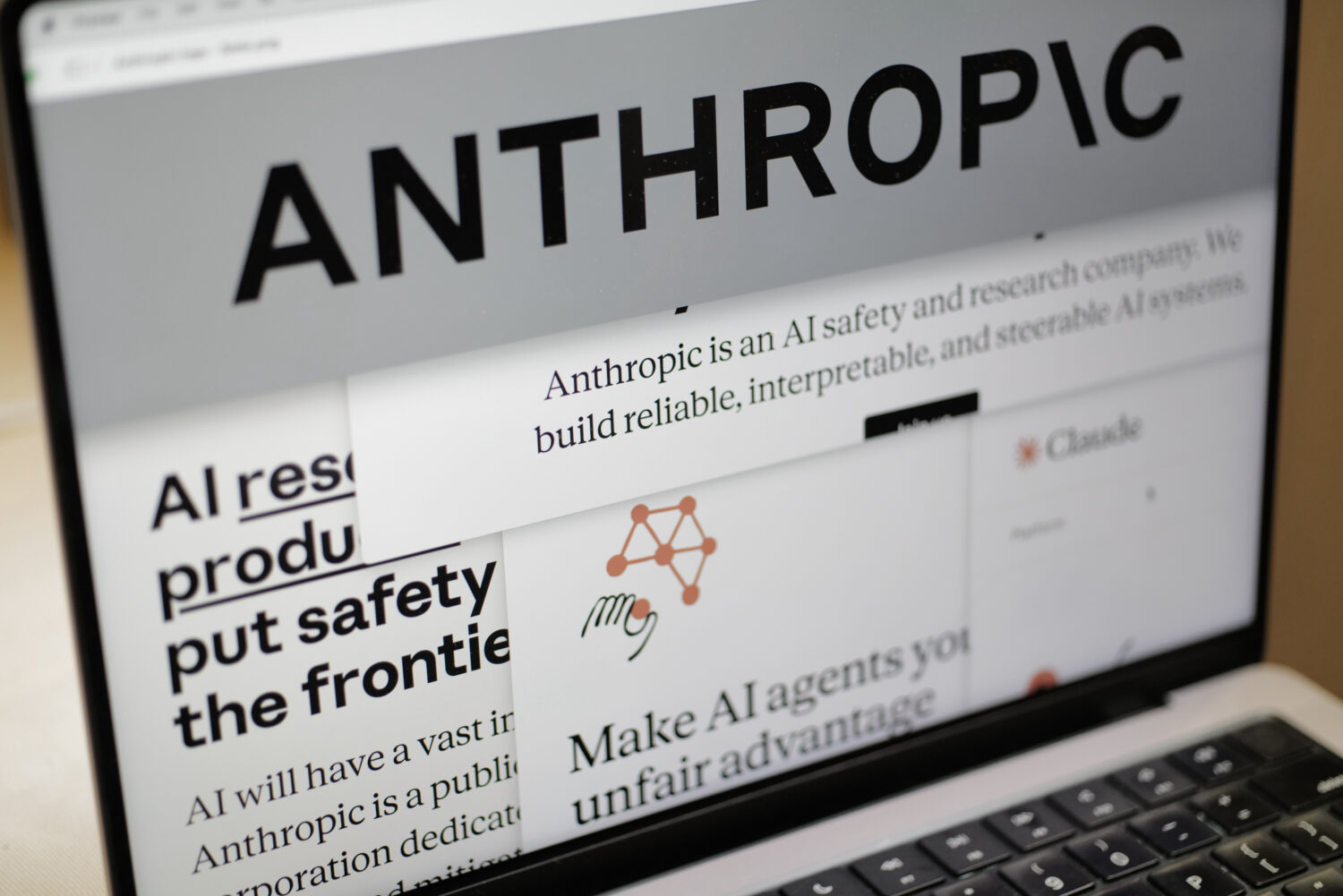 Pages from the Anthropic website and the company's logo are displayed on a computer screen in New Y...