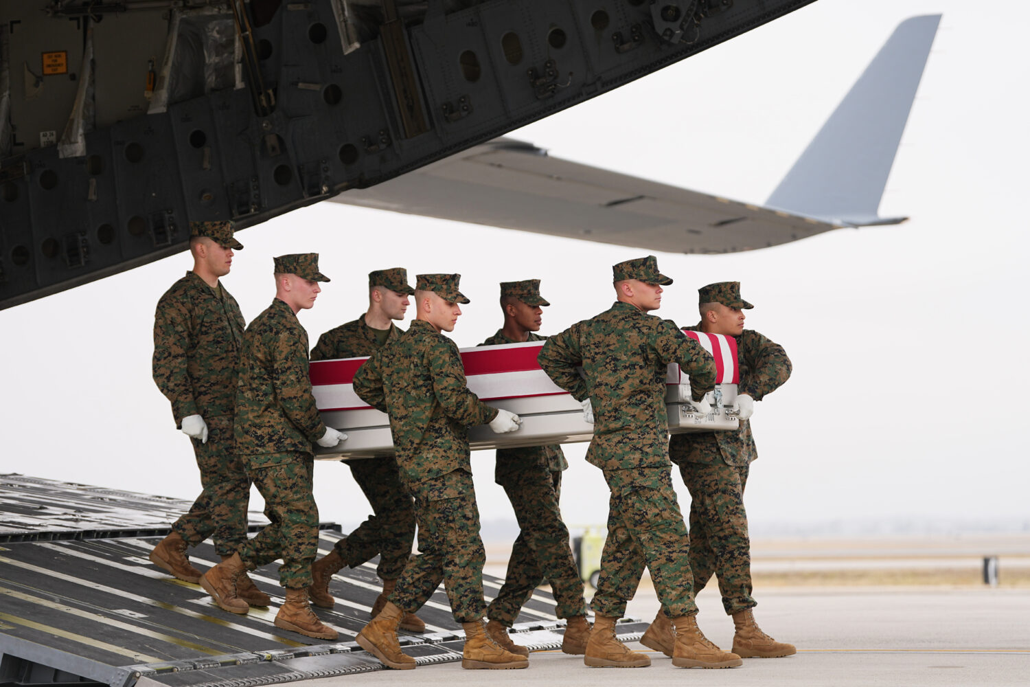 A Marine Corps carry team moves the transfer case containing the remains of U.S. Marine Corps Lance...