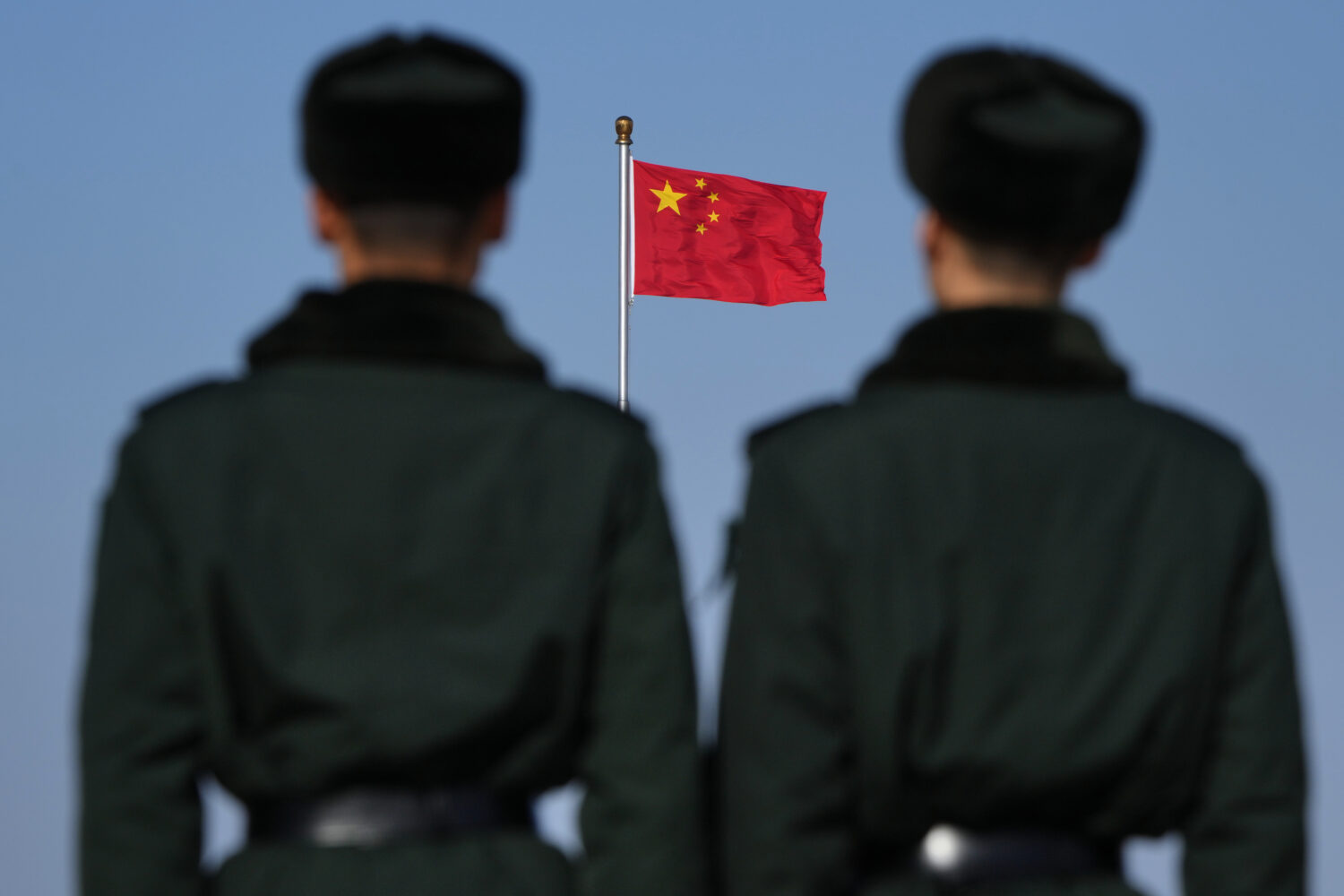 Soldiers stand watch against the national flag on Tiananmen Square during a press conference ahead ...