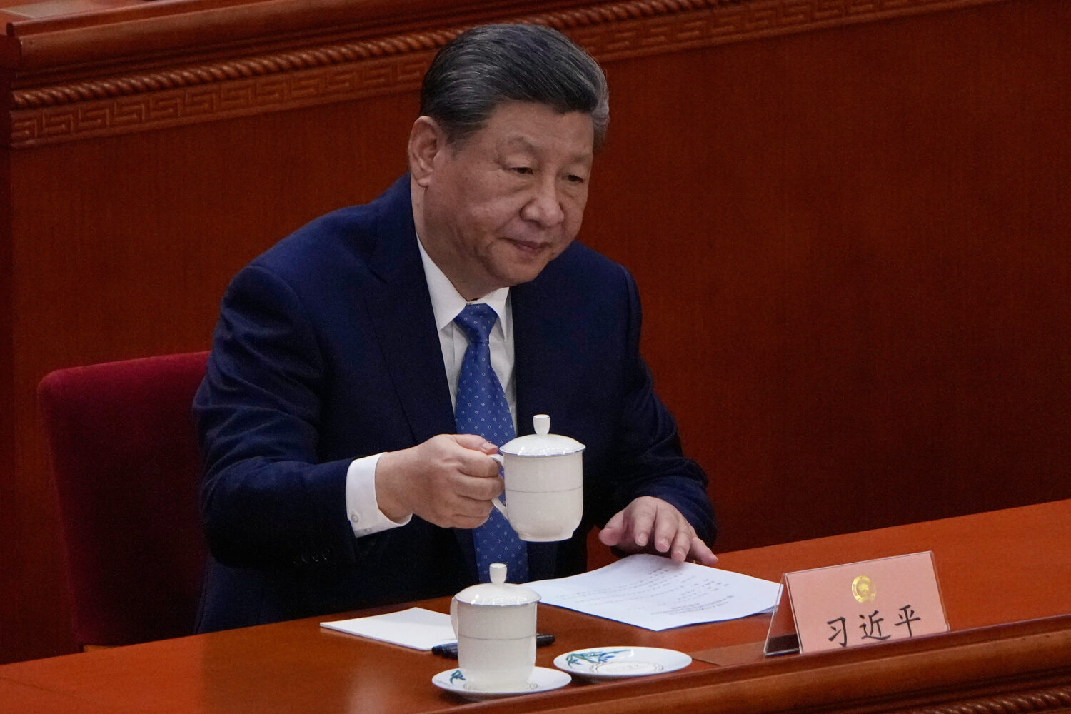 Chinese President Xi Jinping holds his cup of tea during the opening of the Chinese People's Politi...