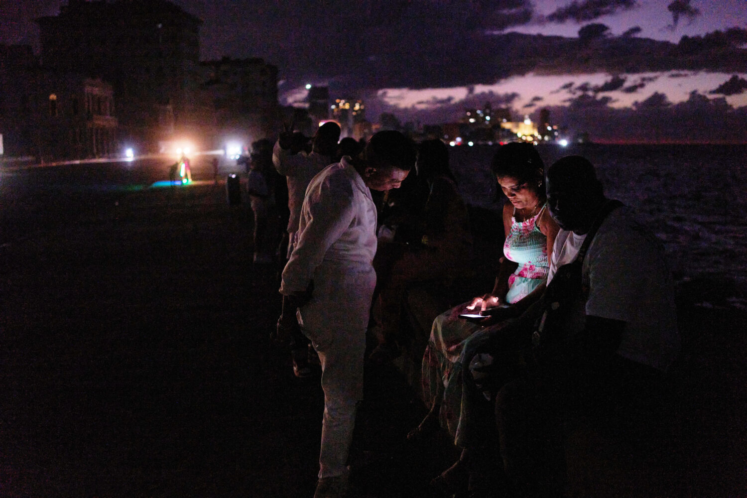 People spend the night in the dark on the Malecon during a blackout in Havana, Cuba, Saturday, Marc...