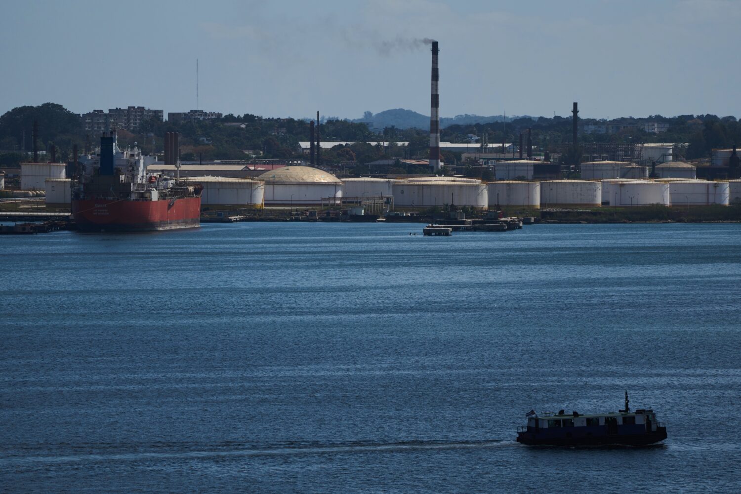 A ferry crosses Havana Bay past the Nico Lopez oil refinery where a Cuban tanker is anchored in Hav...