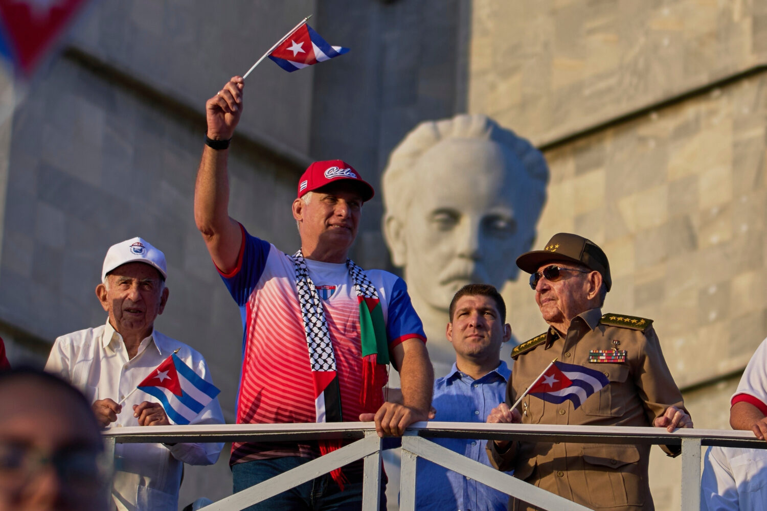 FILE - Cuba's President Miguel Diaz-Canel holds up a Cuban flag as he watches the May Day parade ne...