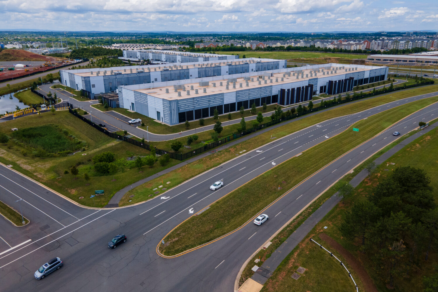 FILE - Cars drive past data centers that house computer servers and hardware required to support mo...