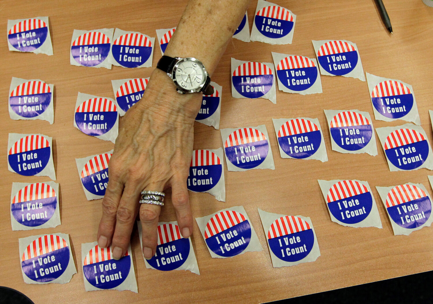 FILE - An election judge arranges "I Vote, I Count" stickers on a table in the Marion County Clerks...