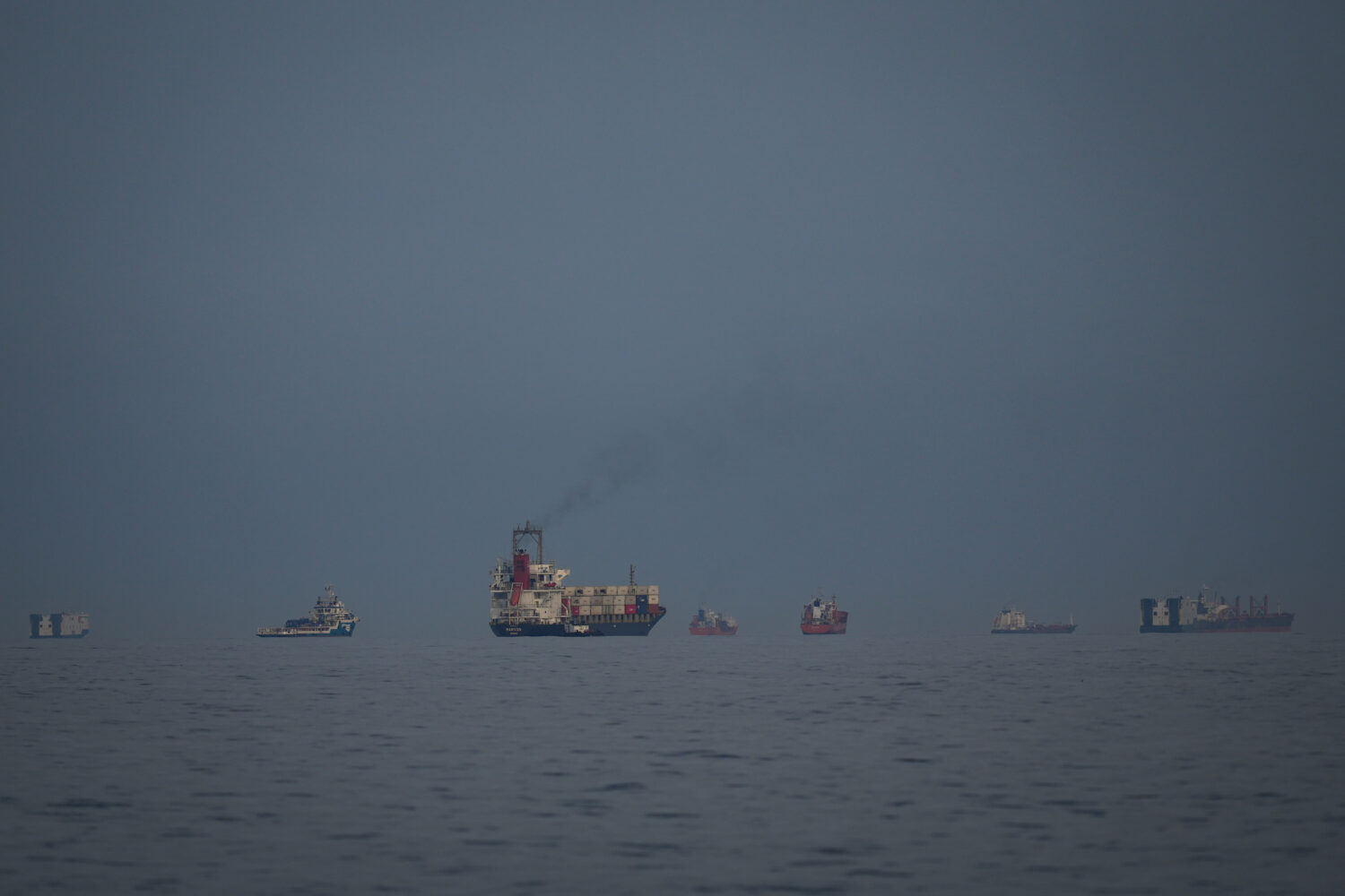 Oil tankers and cargo ships line up in the Strait of Hormuz as seen from Khor Fakkan, United Arab E...