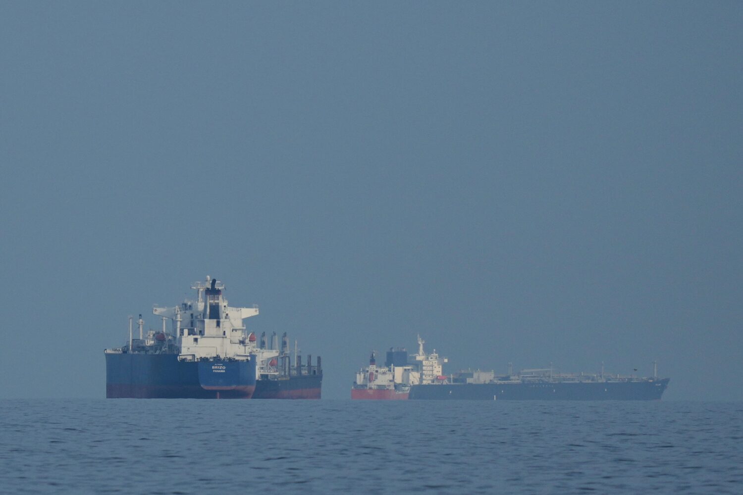 Oil tankers and cargo ships line up in the Strait of Hormuz as seen from Khor Fakkan, United Arab E...