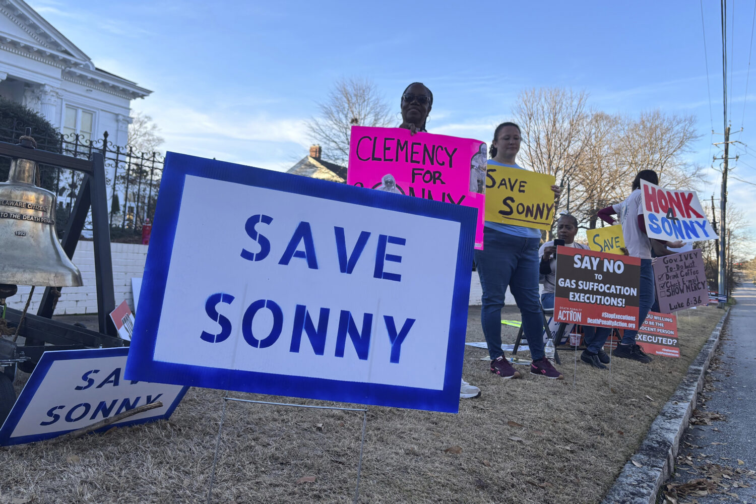 People gather outside the Alabama Governor's Mansion in Montgomery, Ala., on Feb. 16, 2026, to urge...