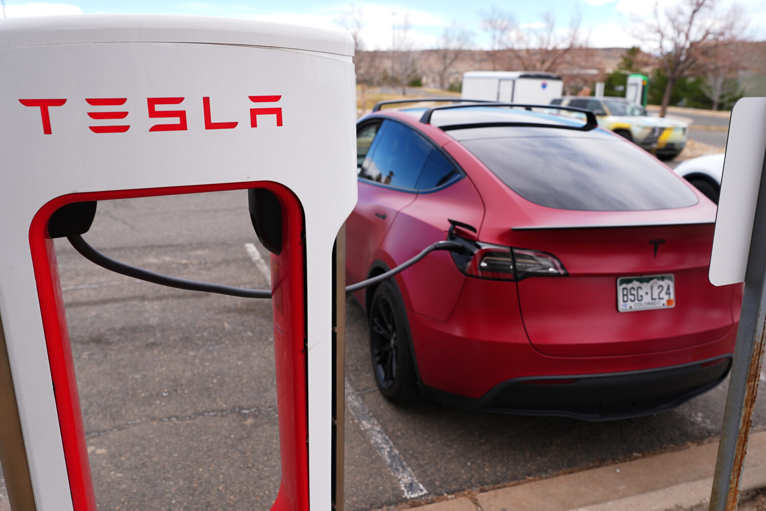 A motorist sits in a Tesla Model 3 at a Tesla charging station Friday, March 13, 2026, in Lakewood,...