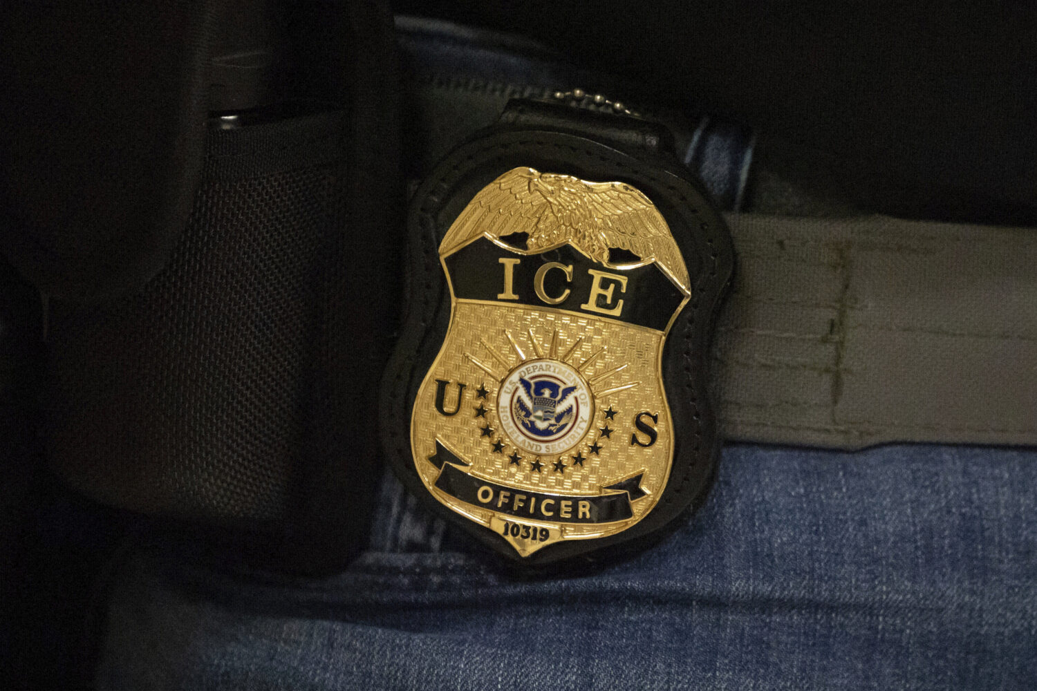 FILE - A federal agent wears an Immigration and Customs Enforcement badge in New York, June 10, 202...