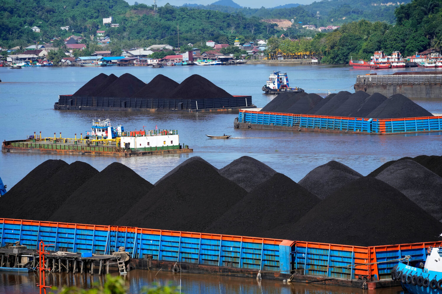 FILE- Barges fully loaded with coal are anchored on Mahakam river in Samarinda, East Kalimantan, In...
