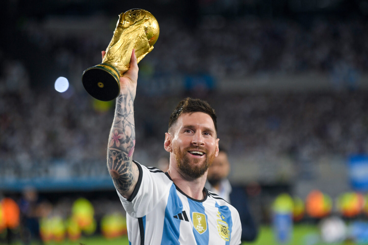FILE - Argentina's Lionel Messi hoists the winning team replica of the FIFA World Cup trophy during...