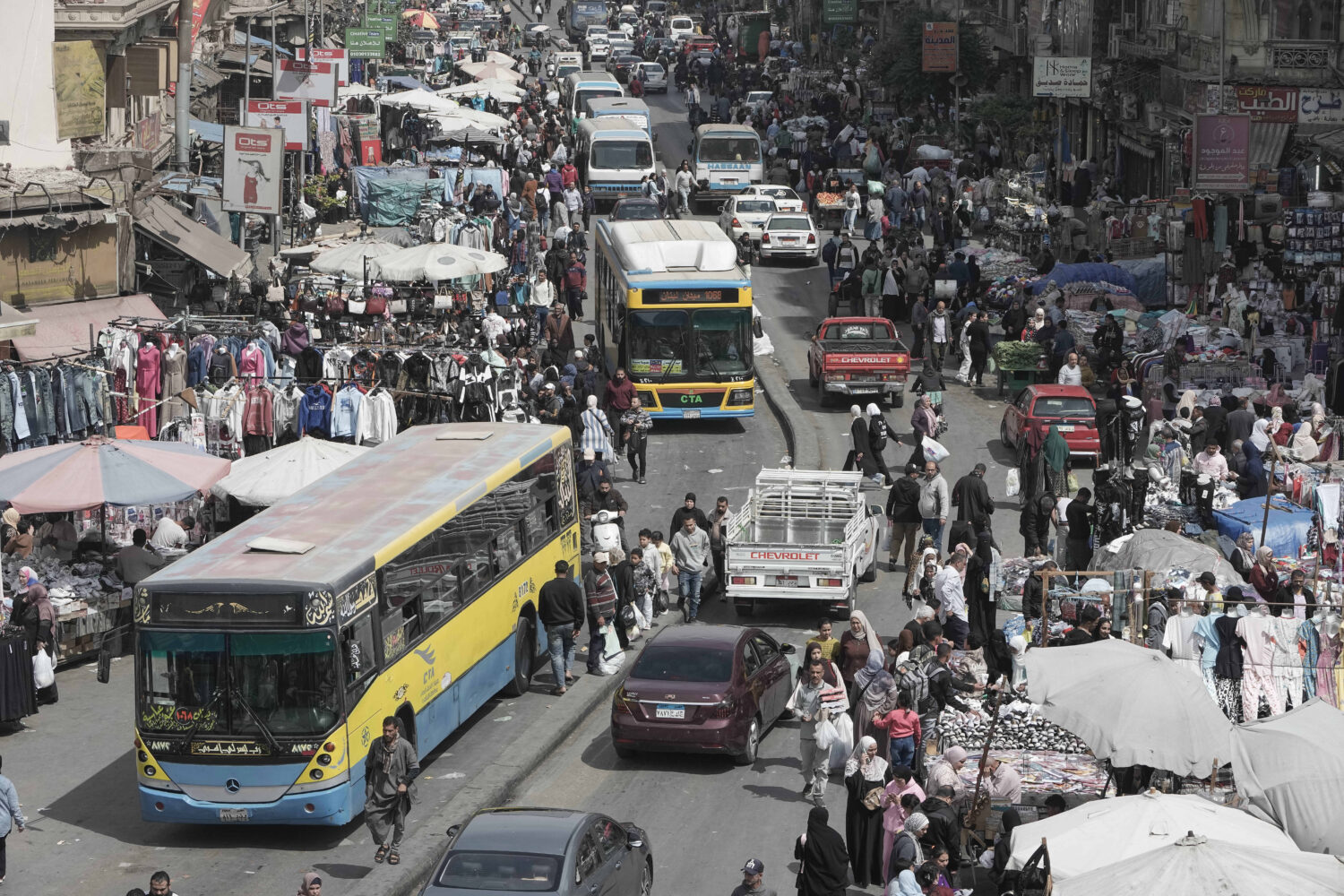 People and vehicles crowd at a popular market in Cairo, Egypt, Tuesday, March 12, 2026. (AP Photo/A...