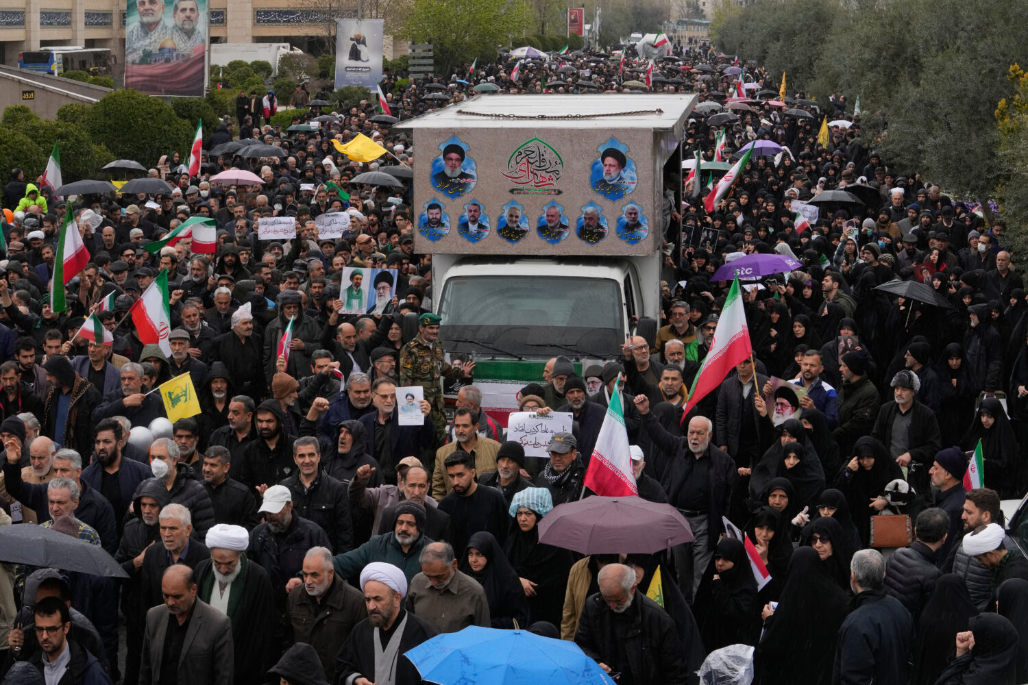 Iranians follow a truck carrying the coffins of Iran's intelligence minister Esmail Khatib and, acc...