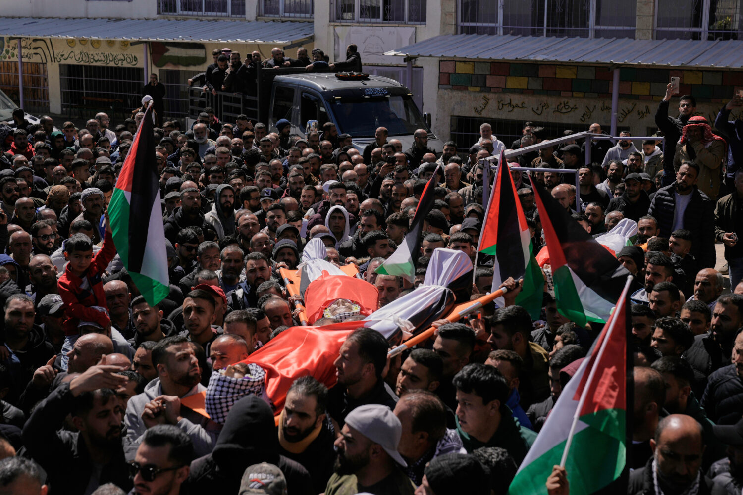 Palestinians gather around the bodies of Thaer Farouq Hamayel, 24, and Farea Hamayel, 57, who were ...