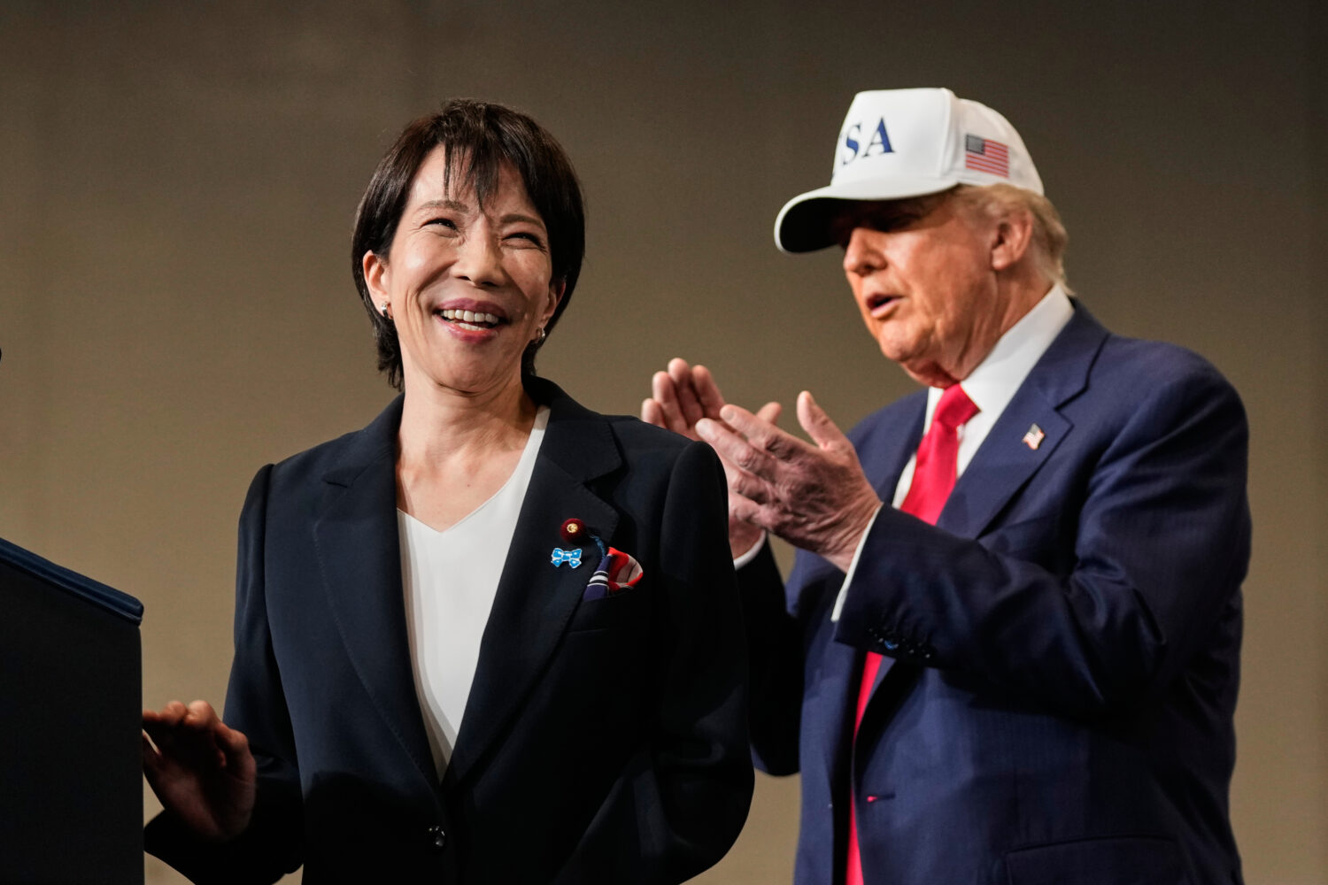 FILE - Japanese Prime Minister Sanae Takaichi, left, with President Donald Trump, reacts as she was...