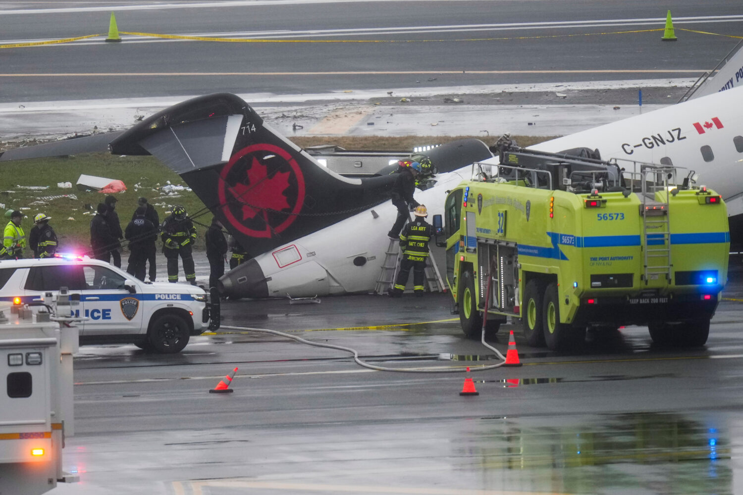 Firefighters and investigators examine the site, Monday, March 23, 2026, where an Air Canada jet ca...