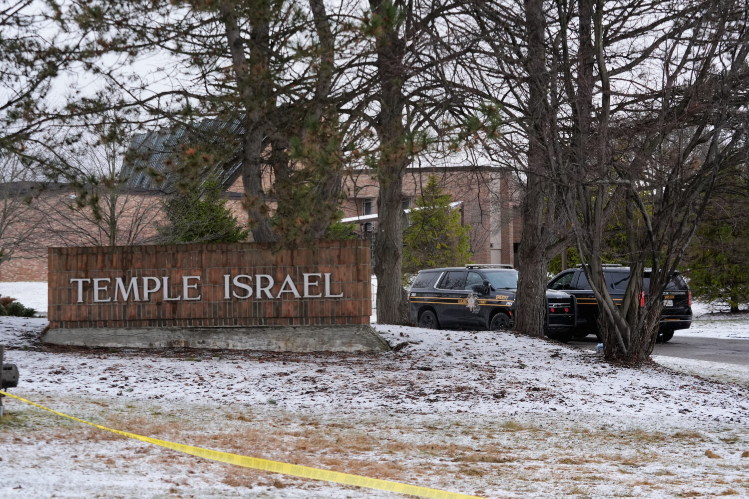Police vehicles sit outside the Temple Israel synagogue Friday, March 13, 2026, in West Bloomfield ...
