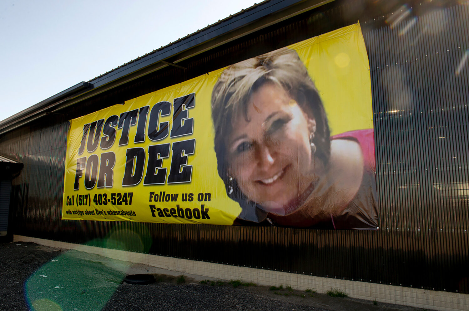 FILE - A banner shows a photo of missing woman Dee Warner in Tipton, Mich., May 9, 2022. (Jacob Ham...