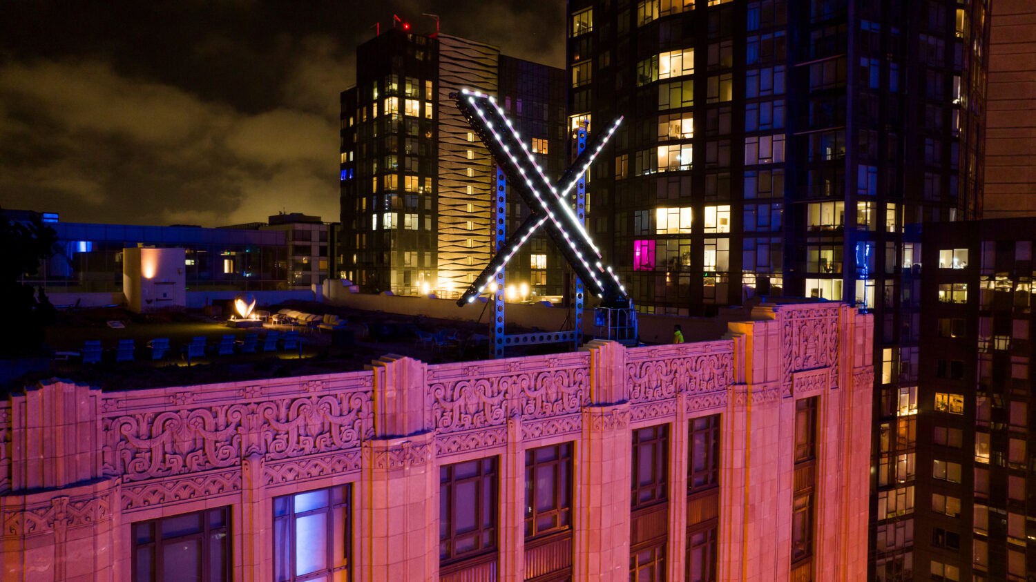 FILE - Workers install lights on an "X" sign atop the company headquarters in downtown San Francisc...