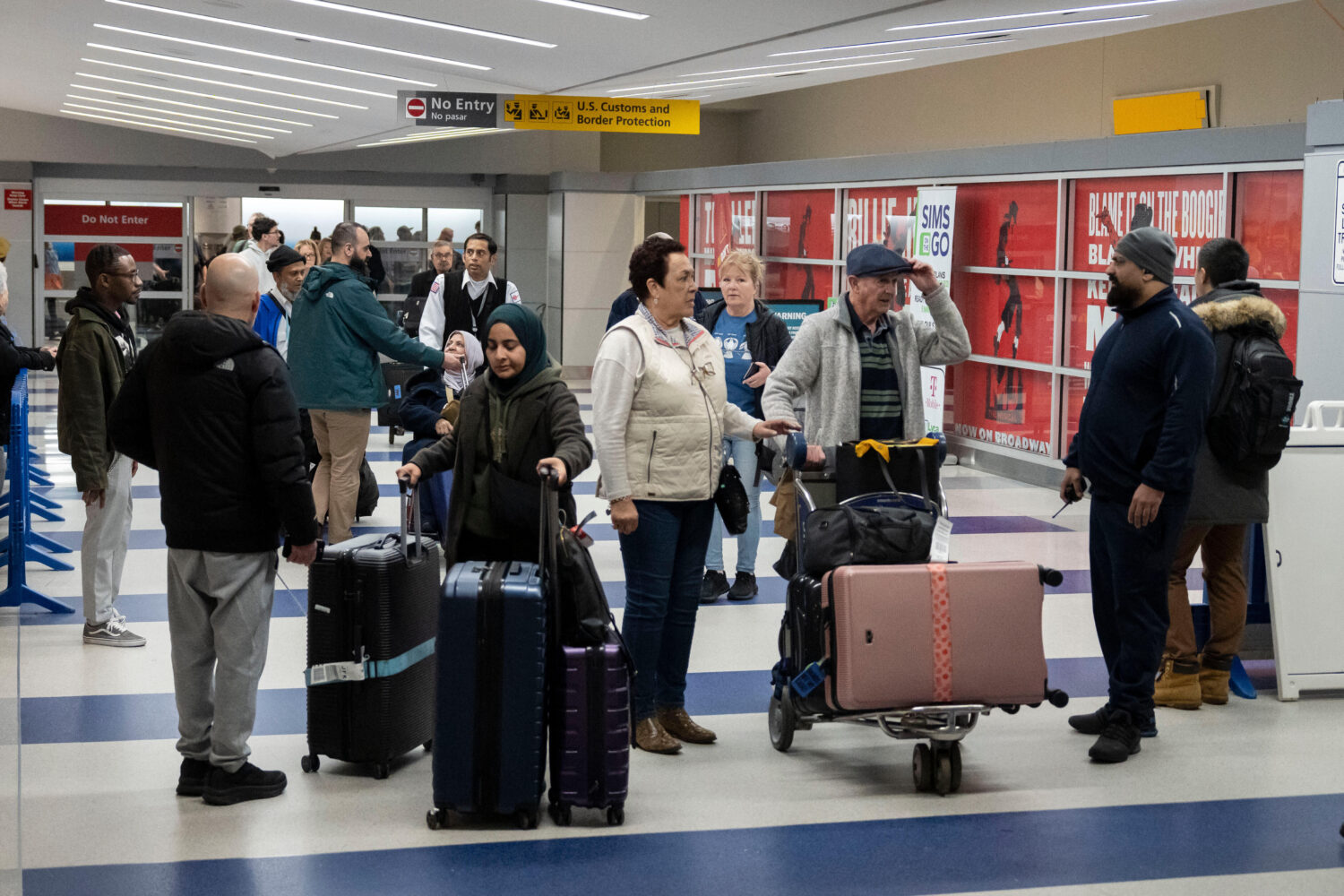 People walk out of the terminal upon their arrival from Amman, Jordan at John F. Kennedy Internatio...