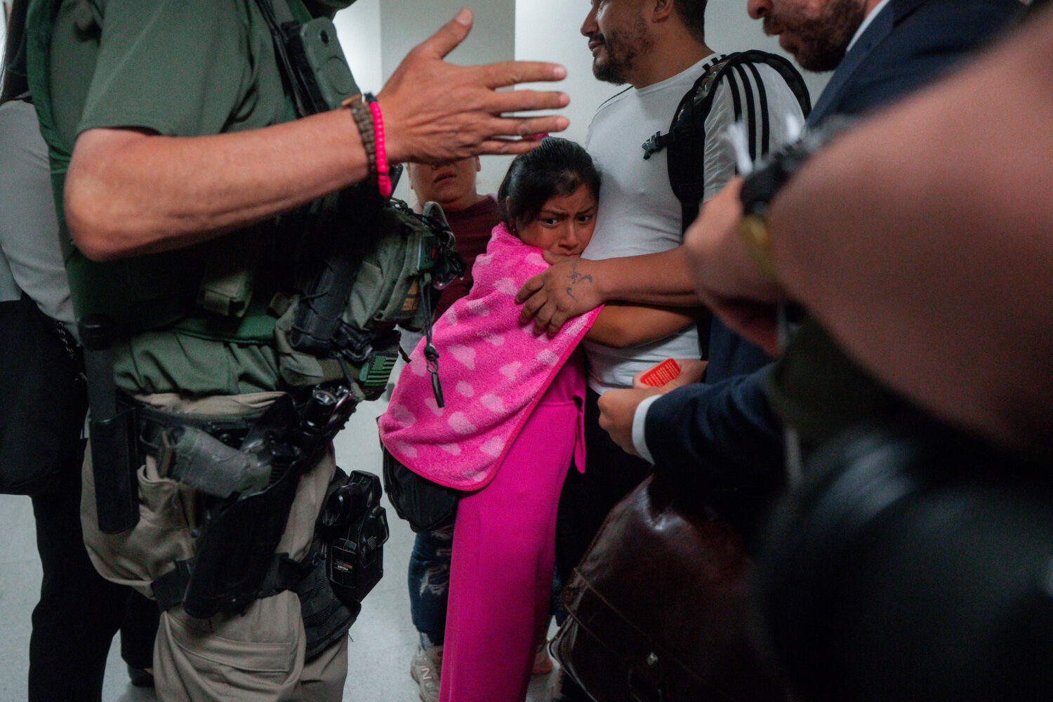 FILE - An asylum seeker from Ecuador hugs her father as he is detained by federal agents, July 31, ...