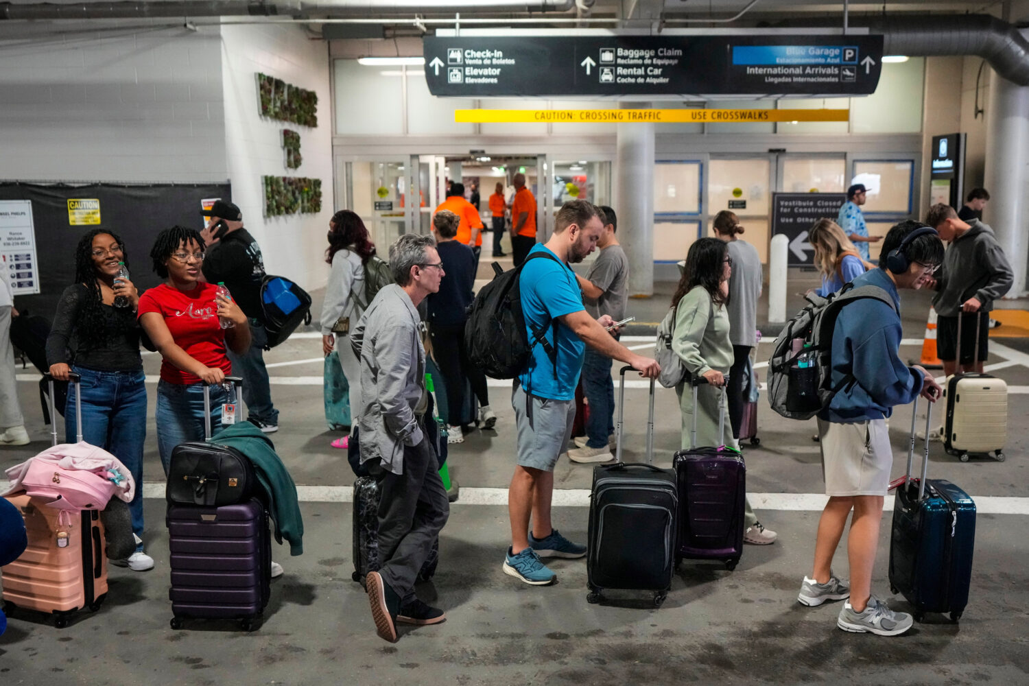 Airline passengers wait in long lines outside the terminal to get through the TSA security screenin...