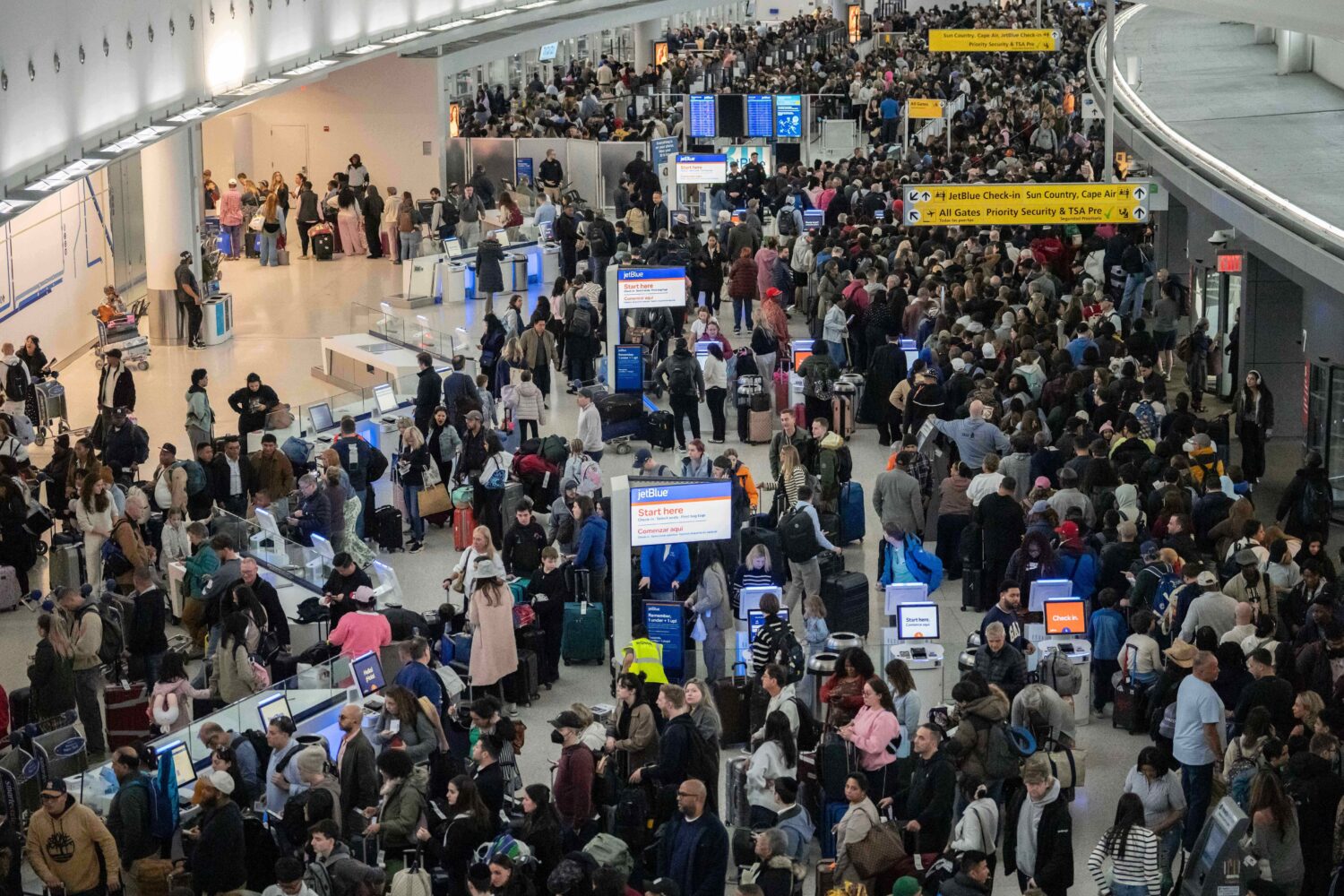 People wait in a TSA line at the John F. Kennedy International Airport, Sunday, March 22, 2026, in ...