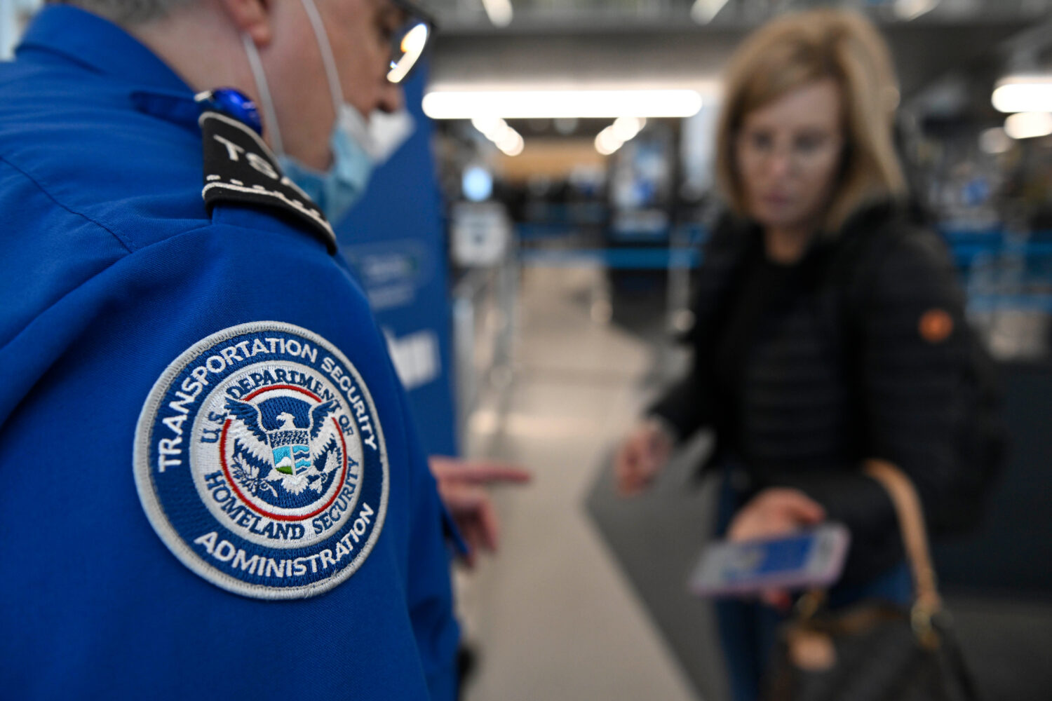 A TSA agent checks a passenger's ticket and boarding pass at Ohare Airport in Chicago, Thursday, Ma...