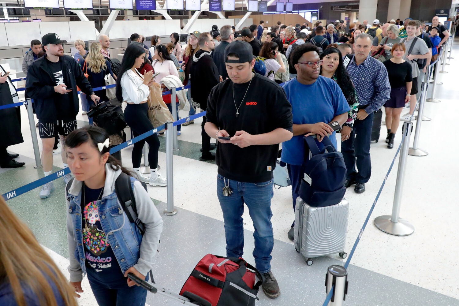 Air travelers endure long lines and two-hour wait times at the TSA security check point at Terminal...