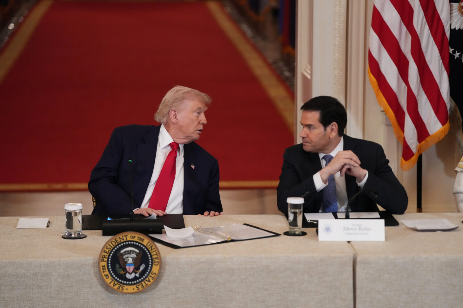 President Donald Trump speaks with Secretary of State Marco Rubio during a roundtable discussion on...