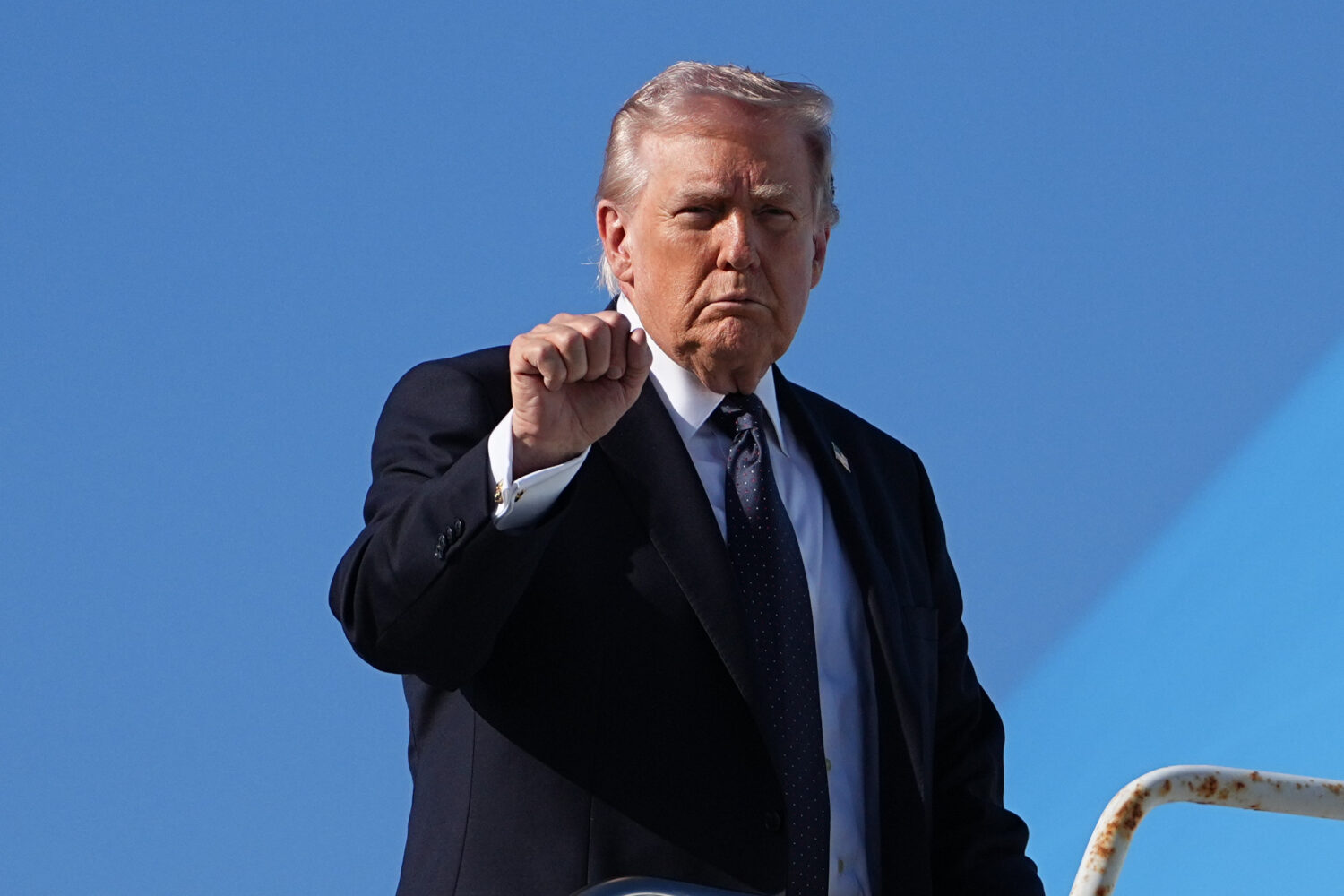 President Donald Trump gestures as he boards Air Force One at Palm Beach International Airport, Sun...