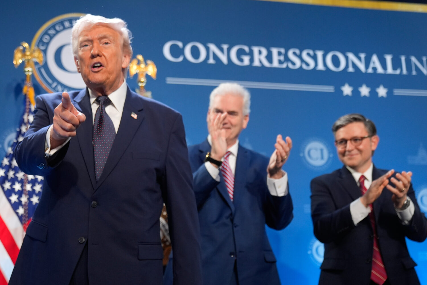 President Donald Trump gestures as Rep. Tom Emmer, R-Minn., and House Speaker Mike Johnson of La., ...