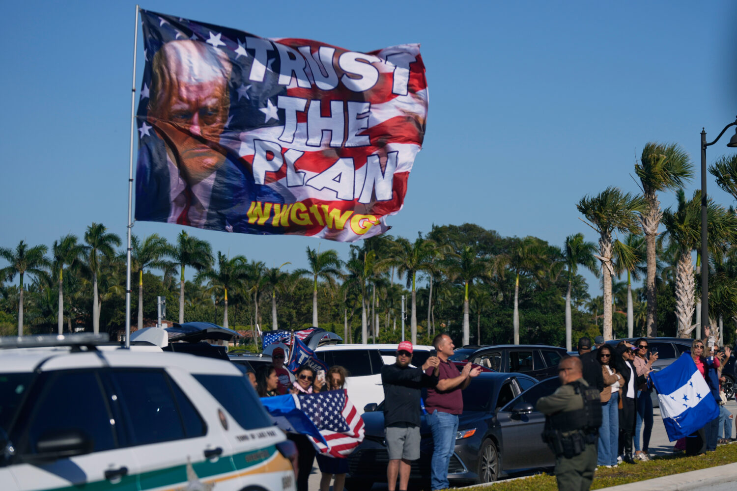 Supporters wave flags, including Honduran flags, as President Donald Trump's motorcade passes by on...