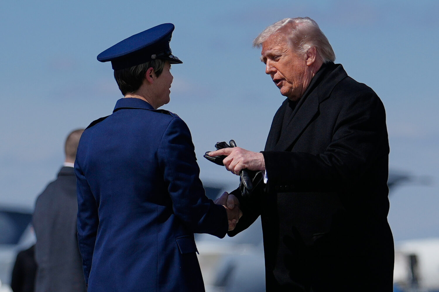 President Donald Trump greets Col. Matha "Jeannie" Sasnett, commander of Air Force Mortuary Affairs...