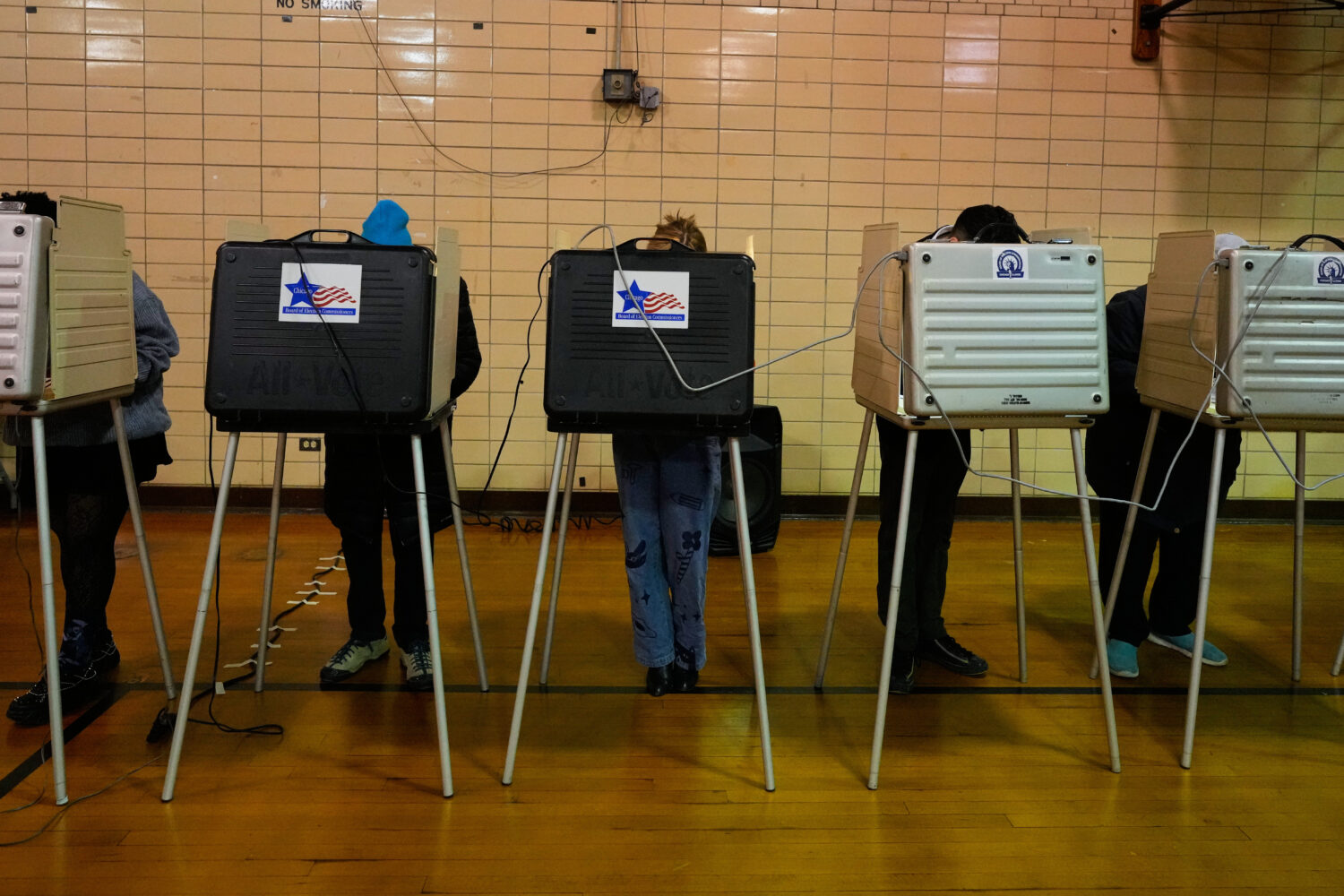 Democratic candidate for Congress, Kat Abughazaleh, center, casts her vote in a primary election fo...